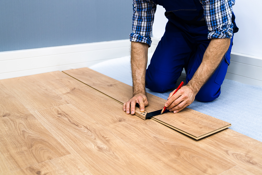 Worker laying and measuring timber floor installers in Sydney 